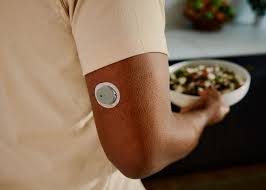 Person wearing CGM holding a bowl of healthy salad